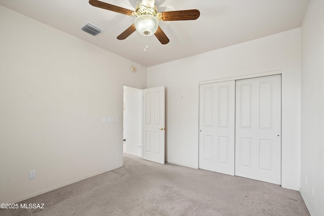 unfurnished bedroom with ceiling fan, a closet, and light colored carpet