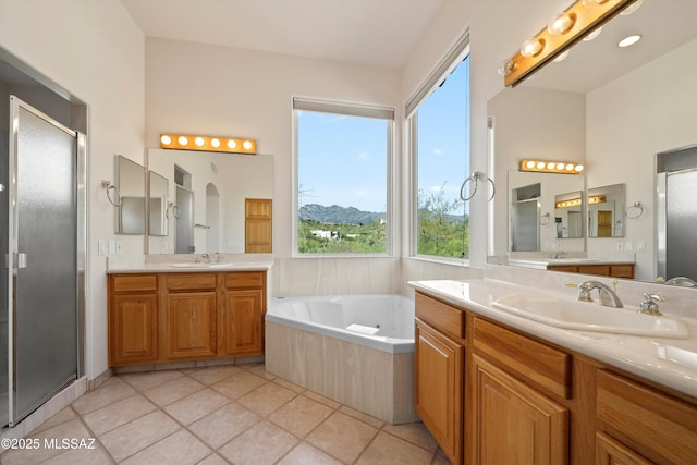 bathroom with a mountain view, shower with separate bathtub, vanity, and tile patterned flooring