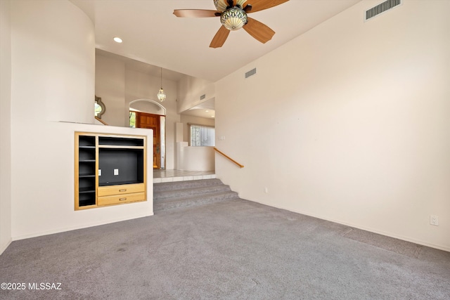 unfurnished living room featuring carpet and ceiling fan