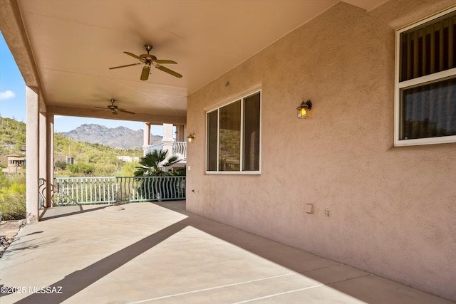 view of patio with ceiling fan and a mountain view