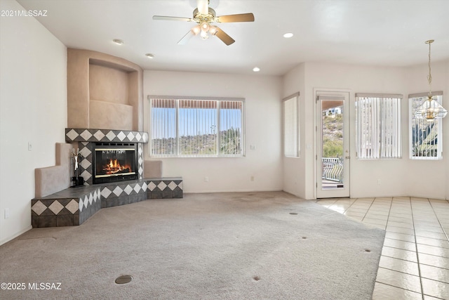 tiled living room with ceiling fan and a fireplace