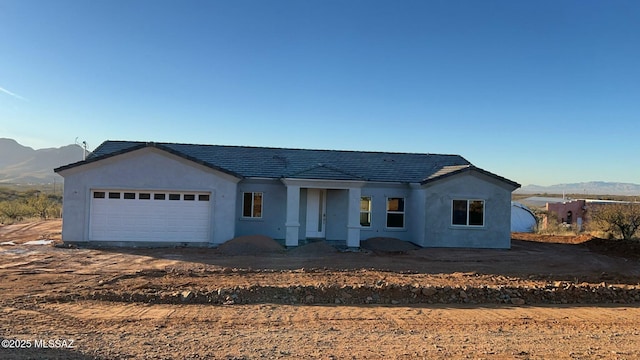 view of front facade with a mountain view and a garage