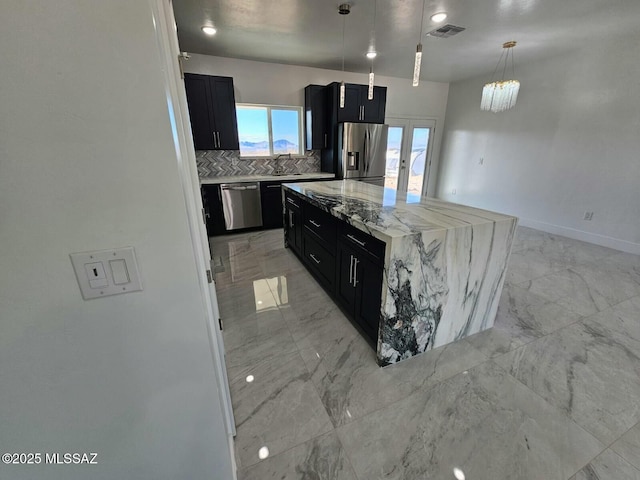 kitchen featuring marble finish floor, visible vents, appliances with stainless steel finishes, a kitchen island, and dark cabinets