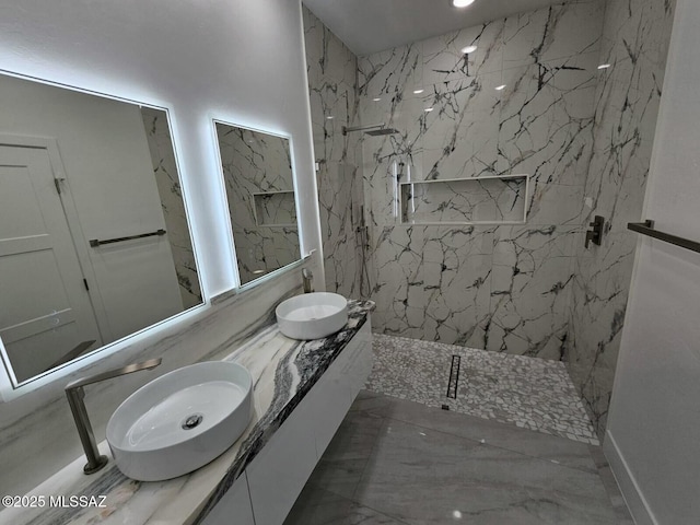 bathroom with marble finish floor, a marble finish shower, and a sink