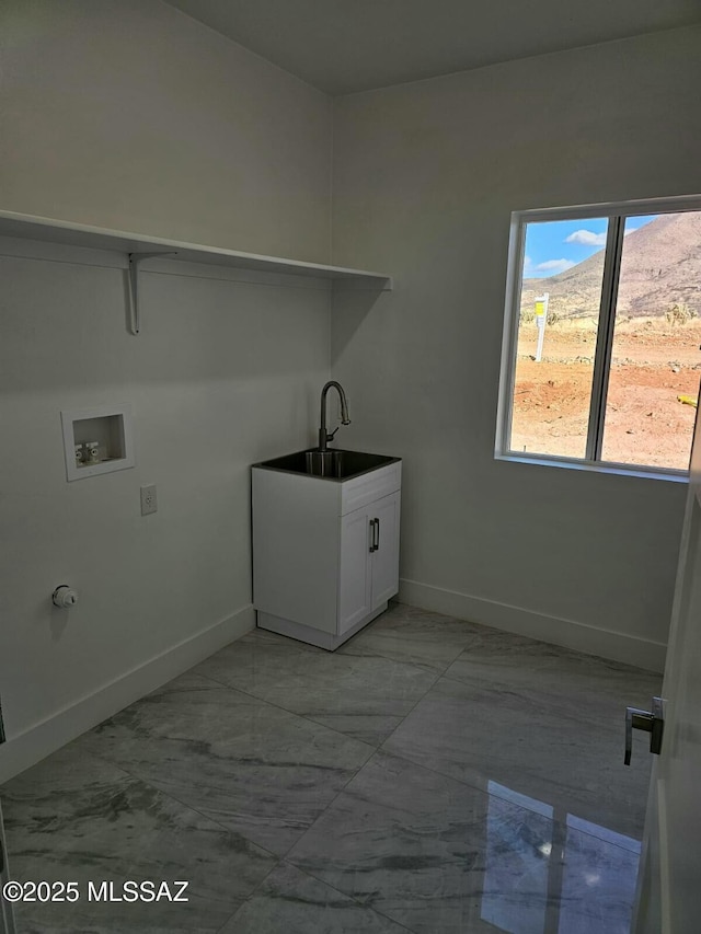 clothes washing area with hookup for a washing machine, laundry area, a sink, baseboards, and marble finish floor