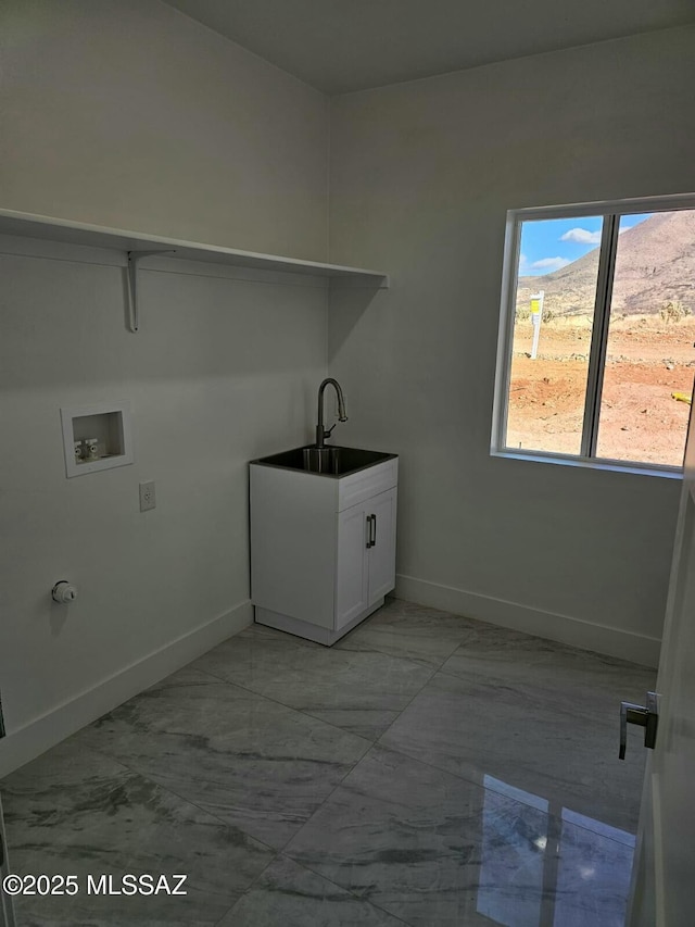 washroom featuring baseboards, washer hookup, laundry area, marble finish floor, and a sink
