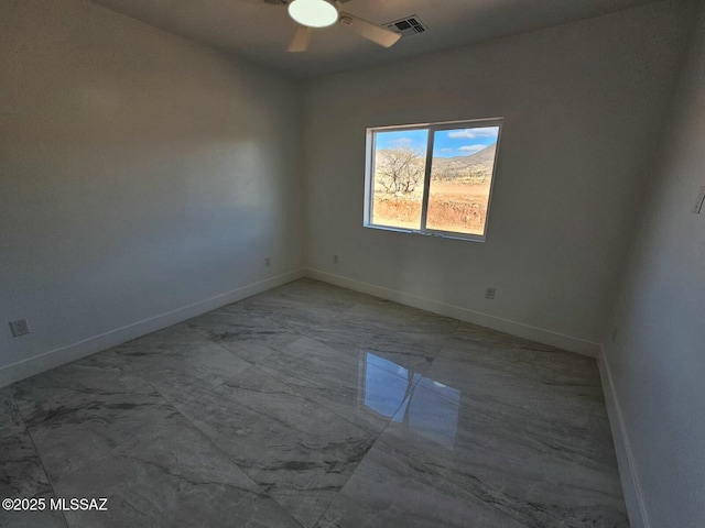 empty room featuring marble finish floor, baseboards, visible vents, and a ceiling fan