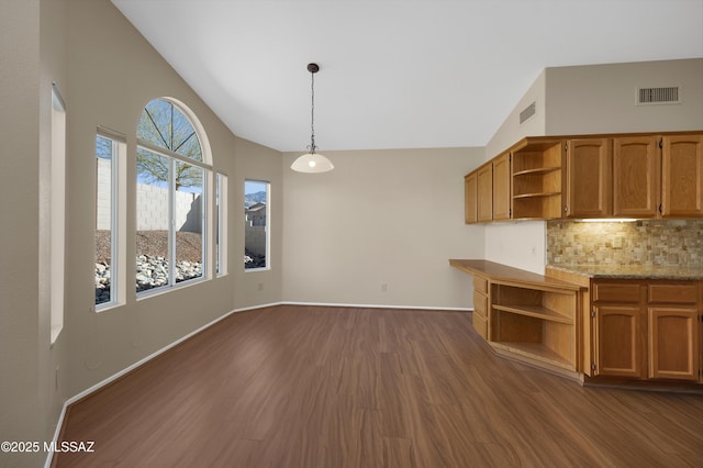 kitchen with backsplash, hanging light fixtures, dark hardwood / wood-style flooring, and lofted ceiling