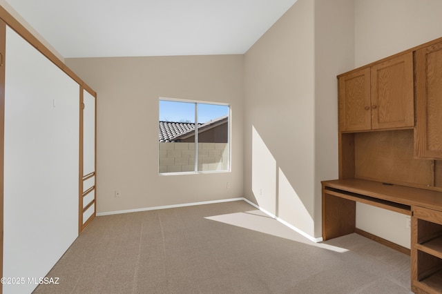 carpeted spare room featuring lofted ceiling