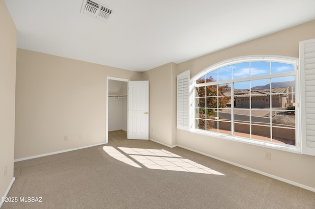 unfurnished bedroom featuring light colored carpet and a closet