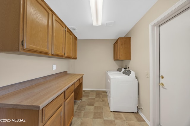 clothes washing area with washing machine and dryer and cabinets