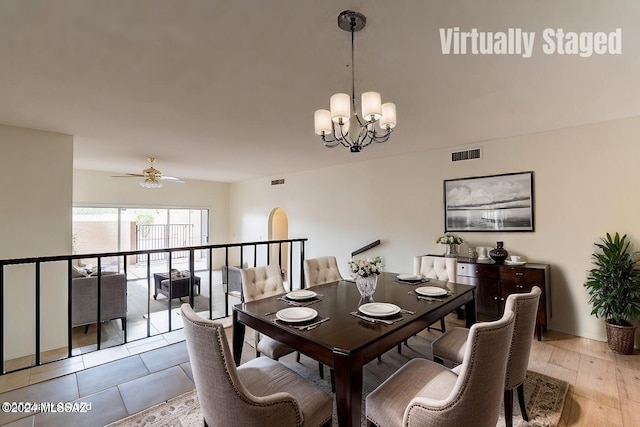 dining space with ceiling fan with notable chandelier