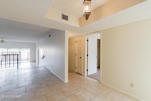 spare room with light tile patterned floors, a textured ceiling, and ceiling fan