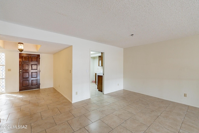 tiled spare room with a textured ceiling