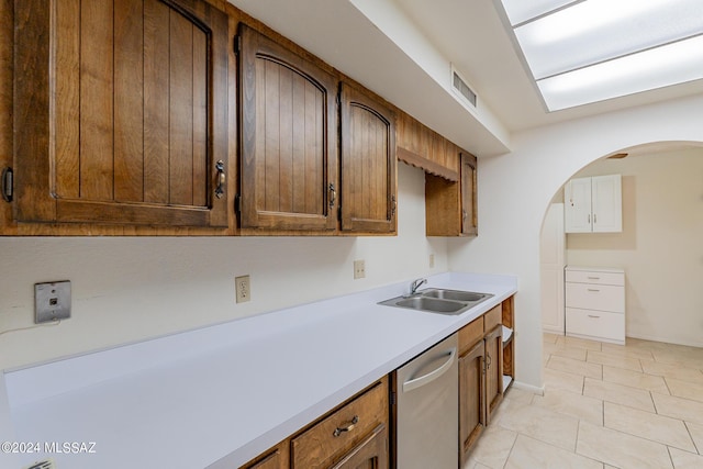 kitchen featuring sink, light tile patterned flooring, and stainless steel dishwasher