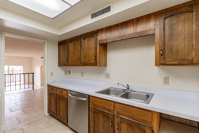 kitchen with dishwasher, light tile patterned floors, and sink