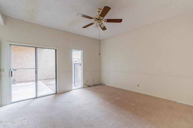 empty room featuring a textured ceiling, light colored carpet, and ceiling fan