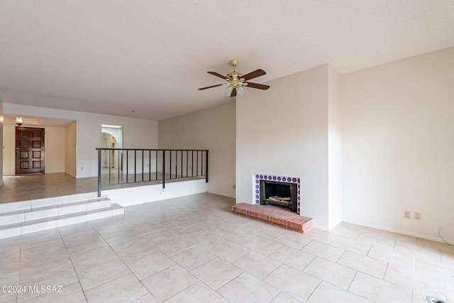 unfurnished living room with ceiling fan, light tile patterned floors, and a textured ceiling