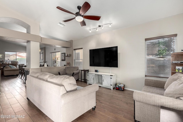 living room with lofted ceiling, a wealth of natural light, and ceiling fan