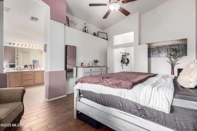 bedroom featuring ensuite bathroom, vaulted ceiling, and ceiling fan