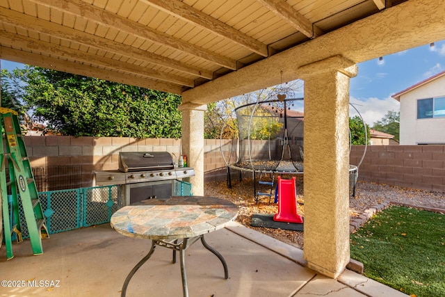 view of patio with grilling area and a trampoline