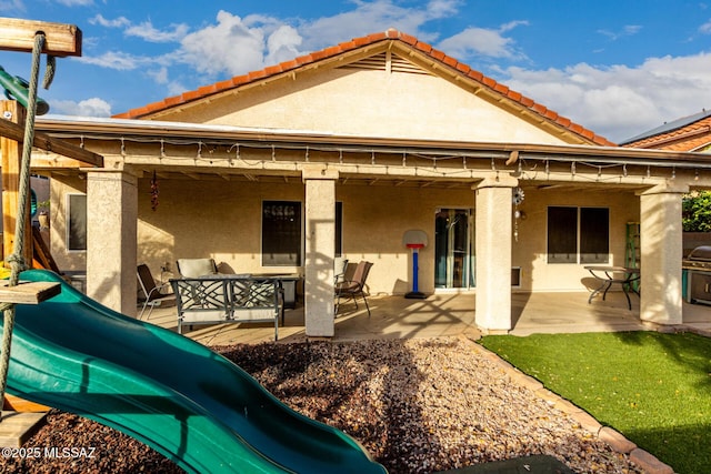 back of house featuring an outdoor hangout area, a playground, and a patio