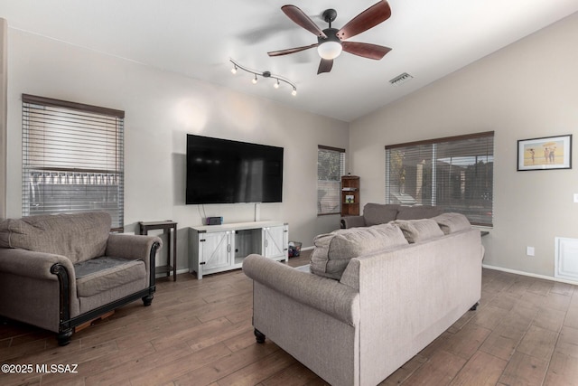 living room featuring dark wood-type flooring, ceiling fan, and vaulted ceiling