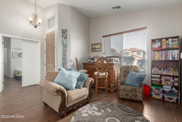 sitting room featuring an inviting chandelier, hardwood / wood-style flooring, and vaulted ceiling