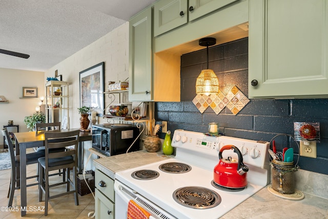 kitchen with white electric range oven, a textured ceiling, decorative light fixtures, light tile patterned floors, and green cabinetry