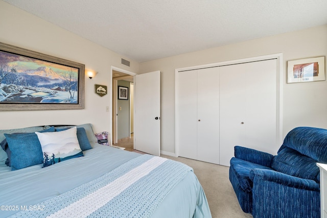 bedroom with light colored carpet, a closet, visible vents, and a textured ceiling