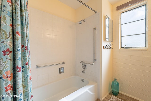 bathroom featuring wood-type flooring and shower / tub combo with curtain