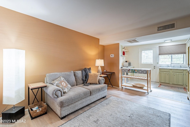 living room with light wood-type flooring and sink