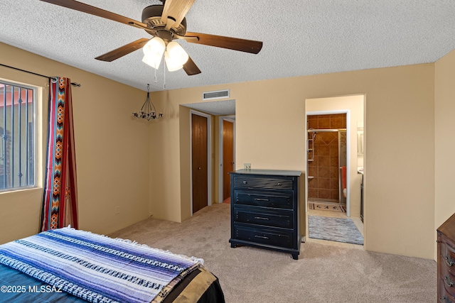 carpeted bedroom featuring ensuite bath, ceiling fan, and a textured ceiling