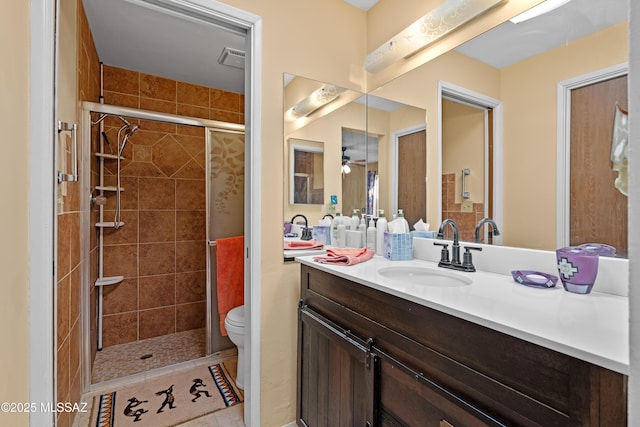 bathroom with vanity, toilet, and a shower with shower door