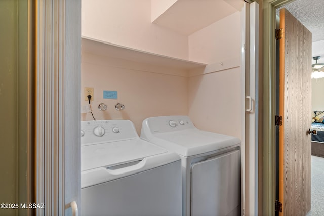 clothes washing area featuring washer and clothes dryer and a textured ceiling