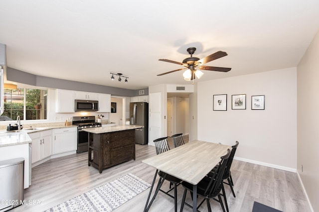 dining space with sink, ceiling fan, and light hardwood / wood-style flooring