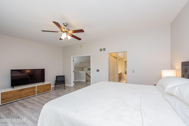 bedroom with ensuite bath, ceiling fan, and light hardwood / wood-style floors