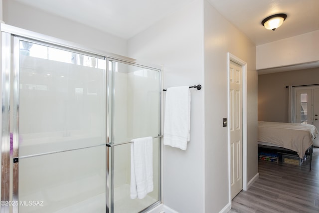 bathroom featuring a shower with shower door and wood-type flooring