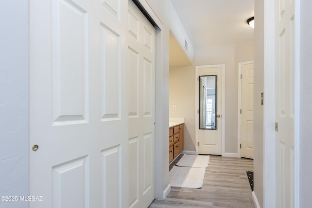 corridor with light hardwood / wood-style floors