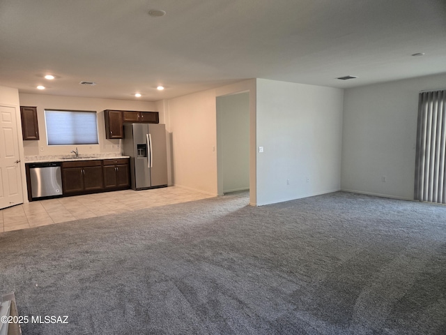 unfurnished living room with sink and light colored carpet