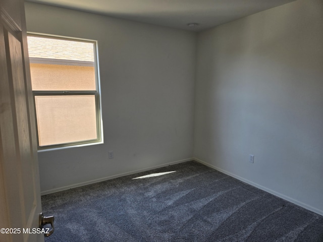 unfurnished room with dark colored carpet