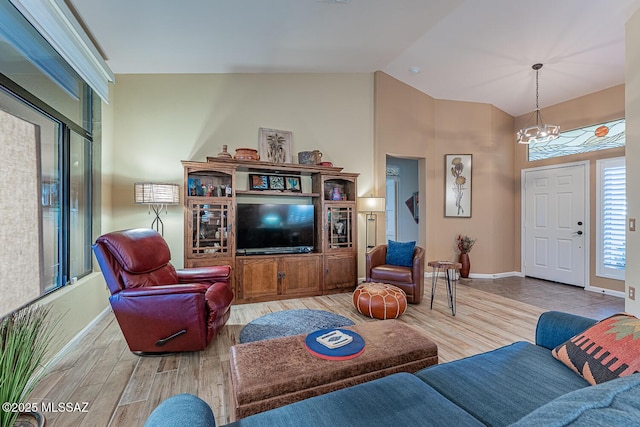 living room featuring lofted ceiling and an inviting chandelier