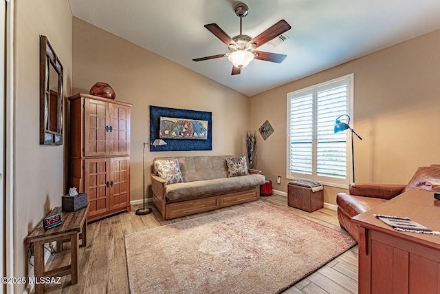 living room featuring ceiling fan, light wood-type flooring, and lofted ceiling