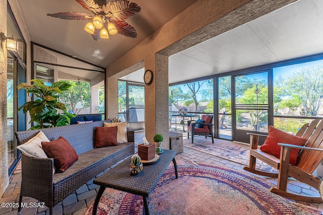 sunroom with ceiling fan and vaulted ceiling