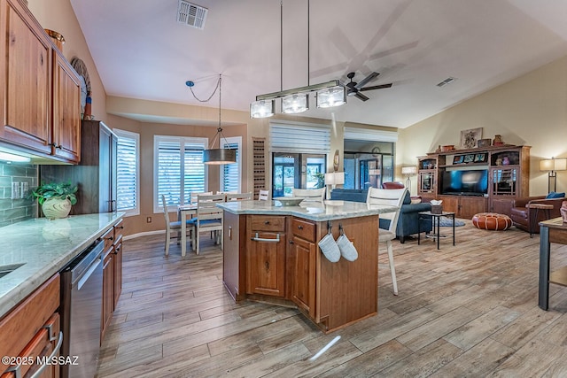 kitchen with light wood-type flooring, a center island, ceiling fan, pendant lighting, and stainless steel dishwasher