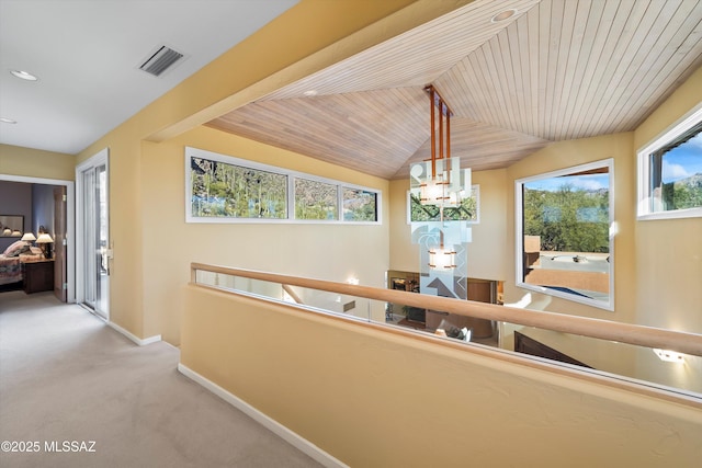 hall with light carpet, lofted ceiling, an inviting chandelier, and wooden ceiling