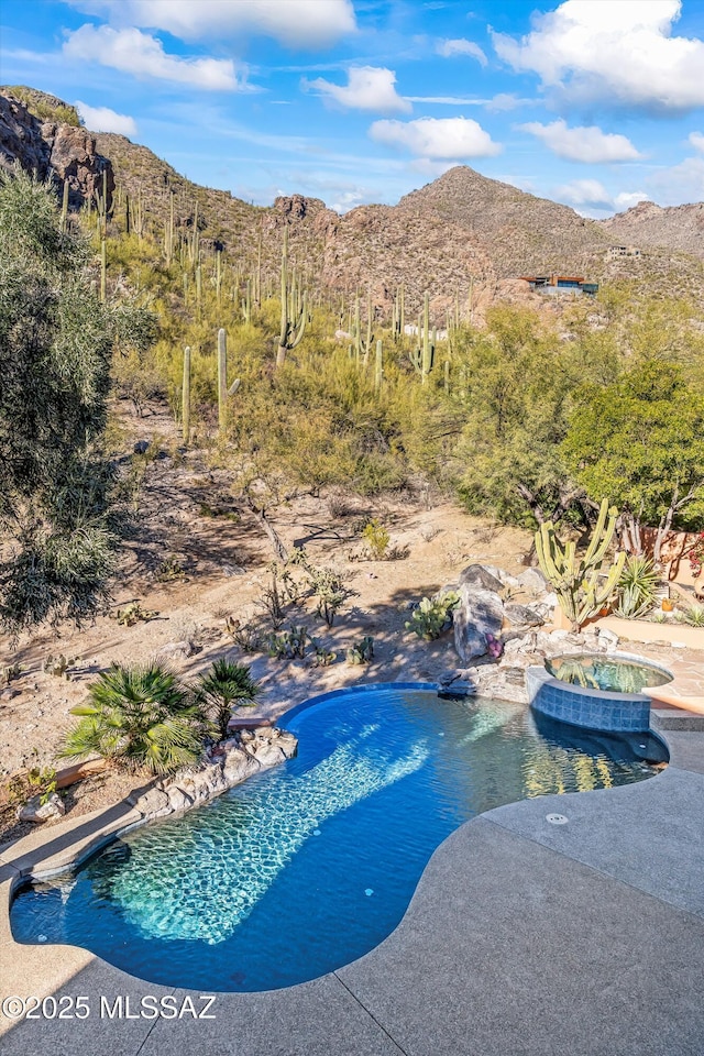 view of swimming pool featuring a mountain view and an in ground hot tub