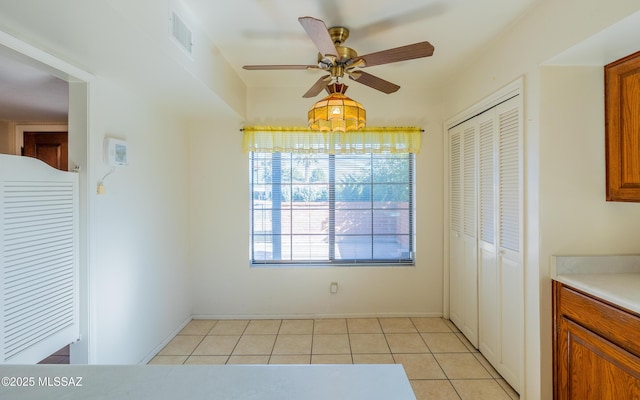 unfurnished dining area featuring ceiling fan and light tile patterned floors