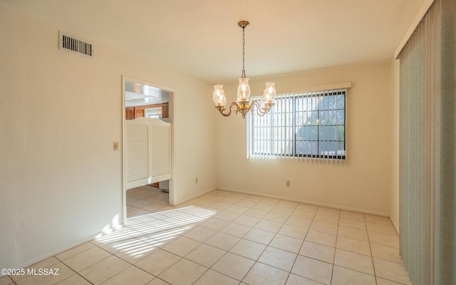 tiled empty room with a notable chandelier