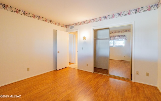 unfurnished bedroom with light hardwood / wood-style flooring and a closet